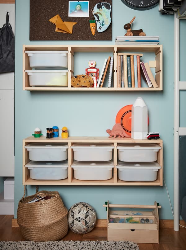 Two units of wall storage from the children’s series TROFAST made from wooden frames and white plastic boxes.