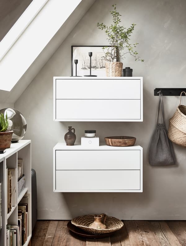 Two white wall cabinets with small, decorative items on top.