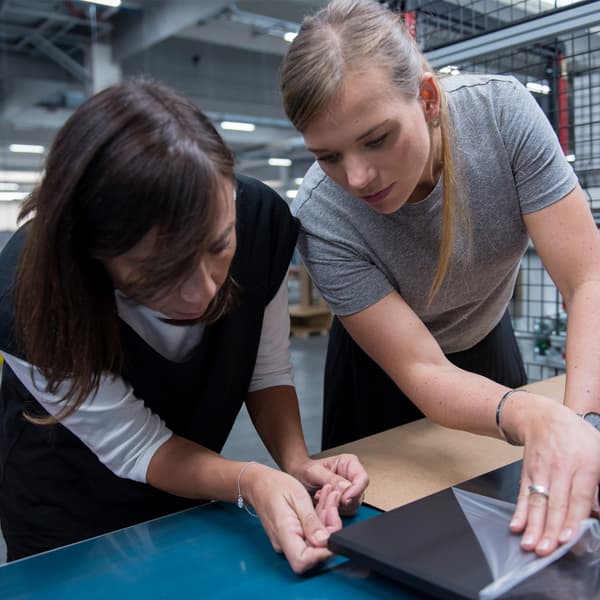 Two young women working as IKEA product designers are examining a product that is being developed.