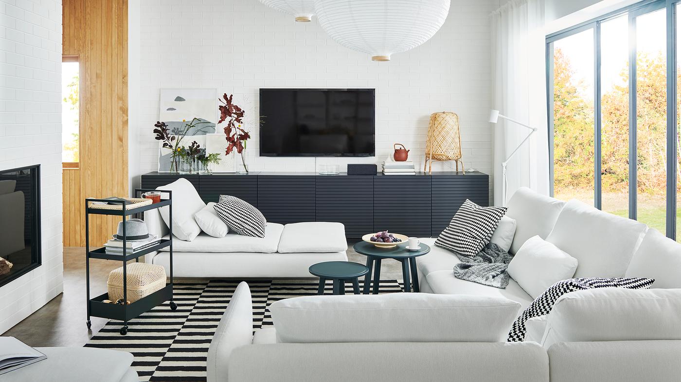 Un amplio living con un gran sofá SÖDERHAMN y un mueble BESTÅ con puertas STOCKVIKEN .