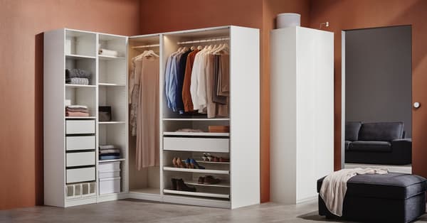 Un armario de almacenamiento blanco en una habitación con paredes de color café rojizo.