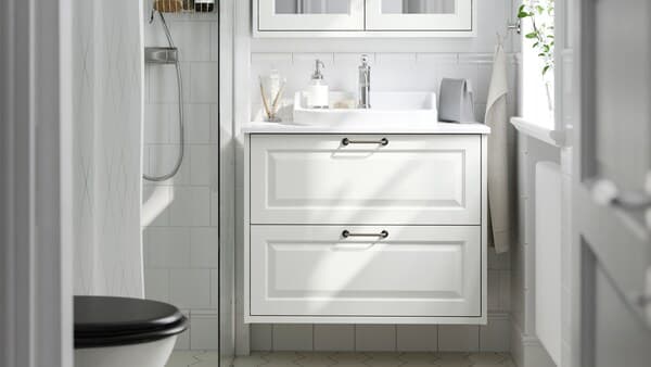 Un baño con muebles de baño TÄNNFORSEN  blancos.