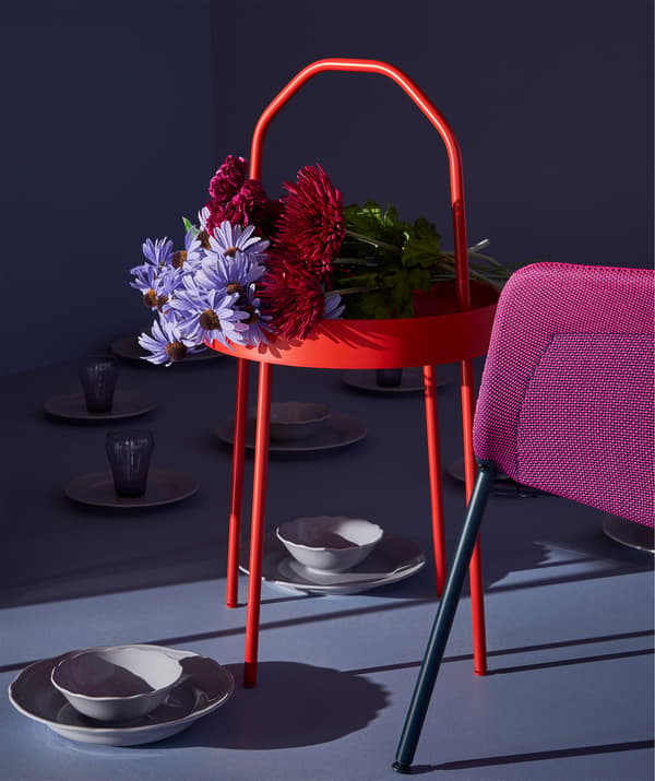 Un bouquet de fleurs orne joliment le plateau d’une table d’appoint BURVIK.