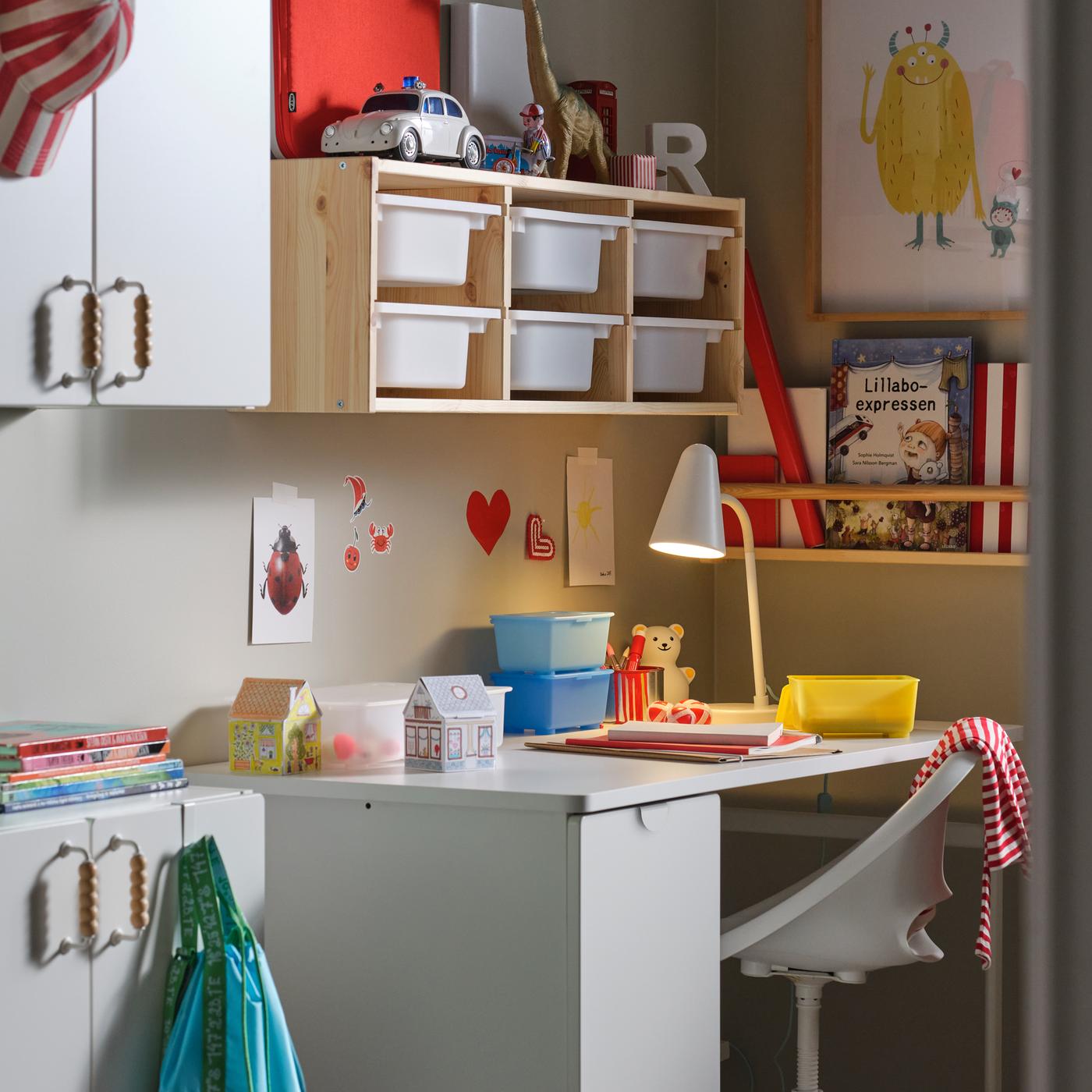 Un bureau LÄRANDE blanc à rangement coulissant, une chaise de bureau pour enfants blanche et un rangement mural en pin/blanc.