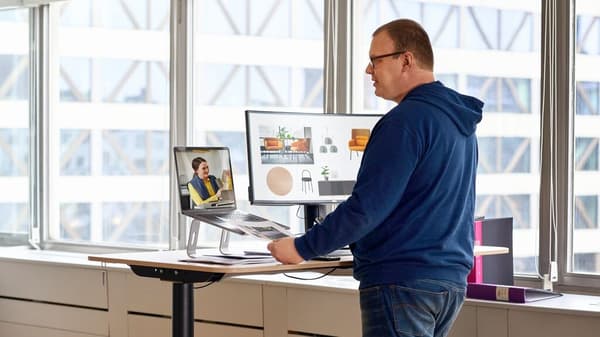 Un cliente di IKEA Business Network è in piedi su una scrivania ed effettua una videochiamata a un collaboratore IKEA.