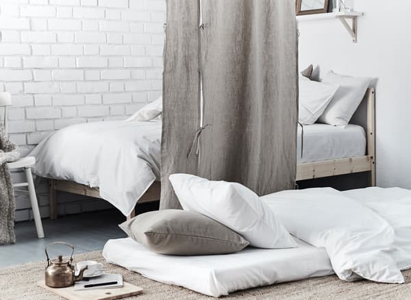 Un coin à dormir supplémentaire est prévu sous la forme d'un matelas posé par terre et d'un tissu tiré faisant office de séparateur de pièce.