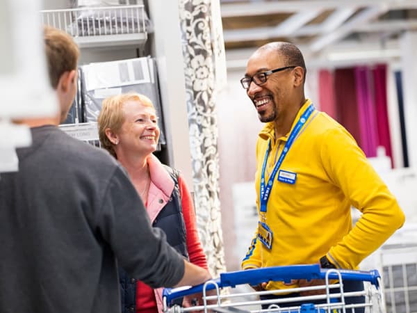 Un collaborateur IKEA aide des clients en magasin.