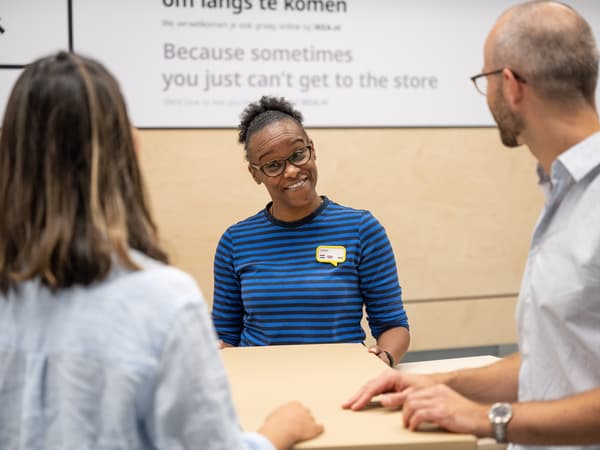 Un collaborateur IKEA sert des clients au comptoir
