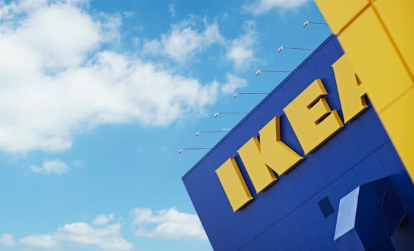 Un día despejado y soleado donde se aprecia una esquina de la icónica tienda de IKEA, con sus colores azules y amarillo. Se aprecia el logo grande.