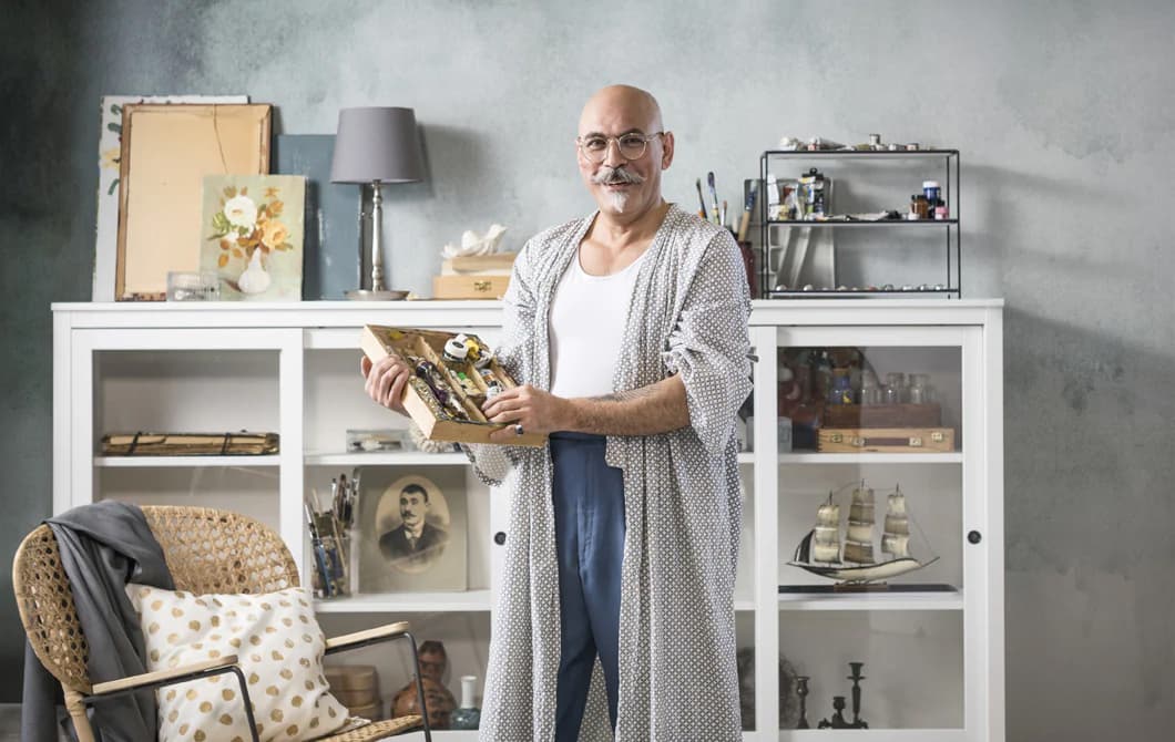 Un homme debout devant une vitrine tient un plateau compartimenté.