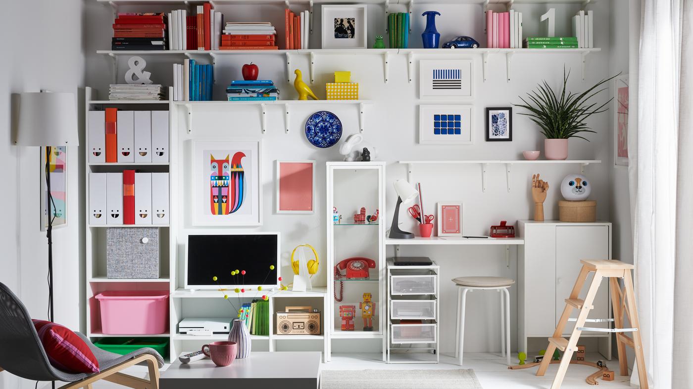 Un living con una pared completa con estantes y repisas dedicados al almacenamiento de libros, juguetes, artículos de colección y revistas.
