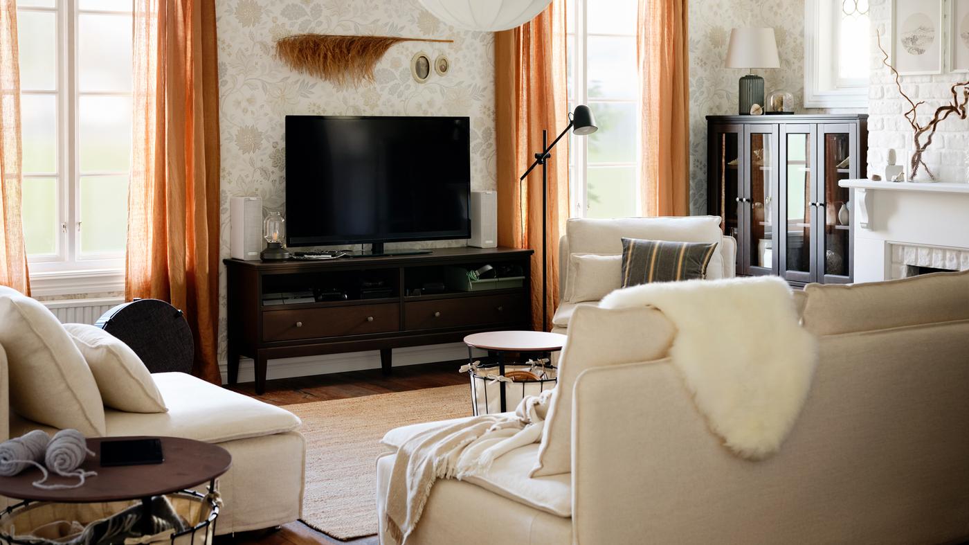 Un mueble de TV junto a dos ventanas con cortinas beige oscuro y dos sofás de una plaza y un sofá de tres plazas SÖDERHAMN.