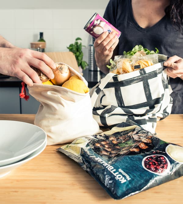 Un parent et un ado rangent des sacs de courses