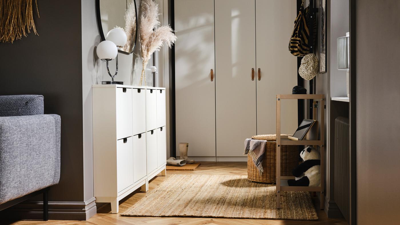 Un piccolo ingresso con un guardaroba PAX/FORSAND a un'estremità e due scarpiere a 4 scomparti STÄLL bianche su un lato - IKEA.