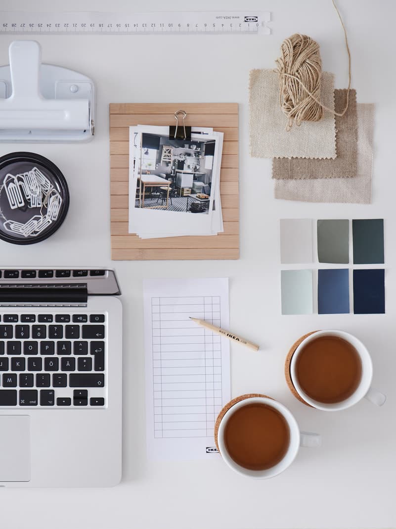 Un plateau de bureau blanc avec divers accessoires et fournitures de bureau disposés symétriquement.