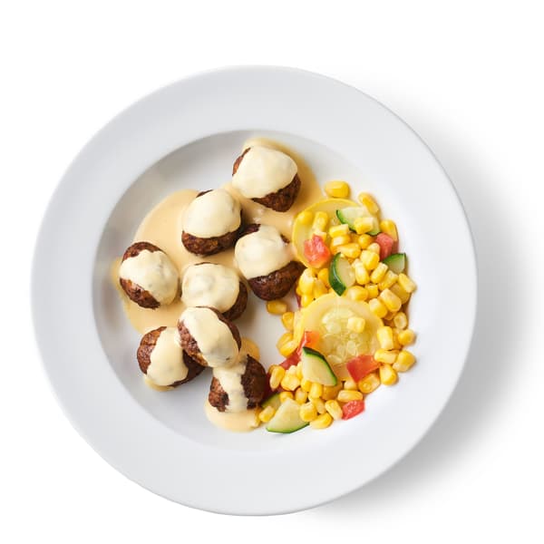Un plato de albóndigas de verduras servido con alioli de limoncillo y un surtido de maíz