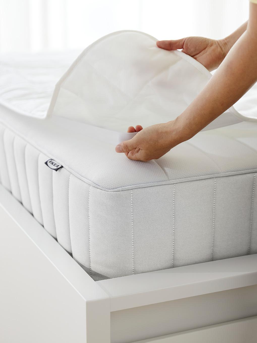un protège-matelas blanc posé sur un matelas