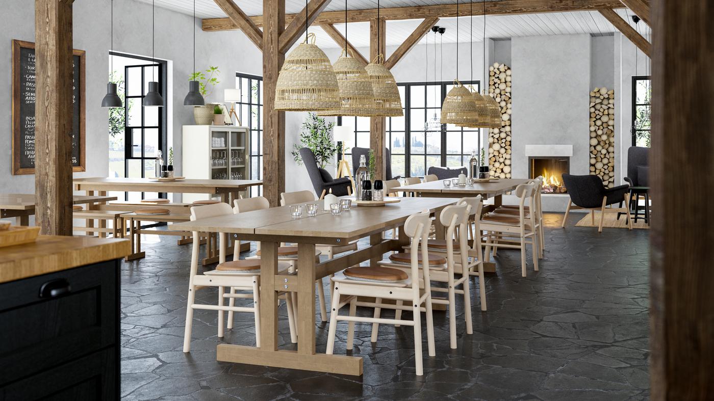 Un restaurant de style lodge avec de longues tables en bois, des chaises en bois, des poutres apparentes et une cheminée.