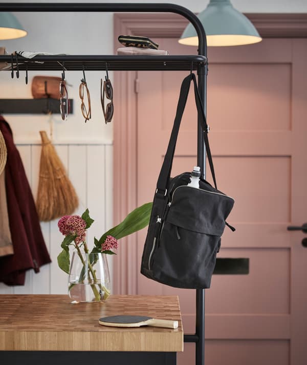 Un sac à bandoulière accroché sur le support d’îlot de cuisine VADHOLMA.