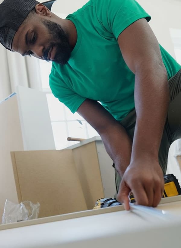 Un Taskrabbit Tasker travaillant à l'assemblage de meubles IKEA chez un client.