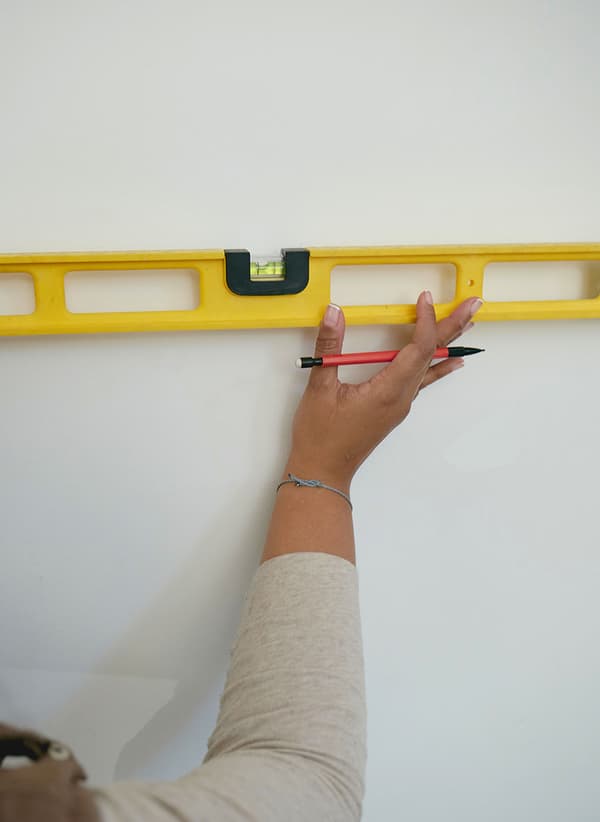 Un Taskrabbit Tasker vérifiant un mur avec un niveau