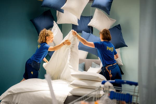Un visual merchandiser IKEA réalise une esquisse, debout à un bureau.