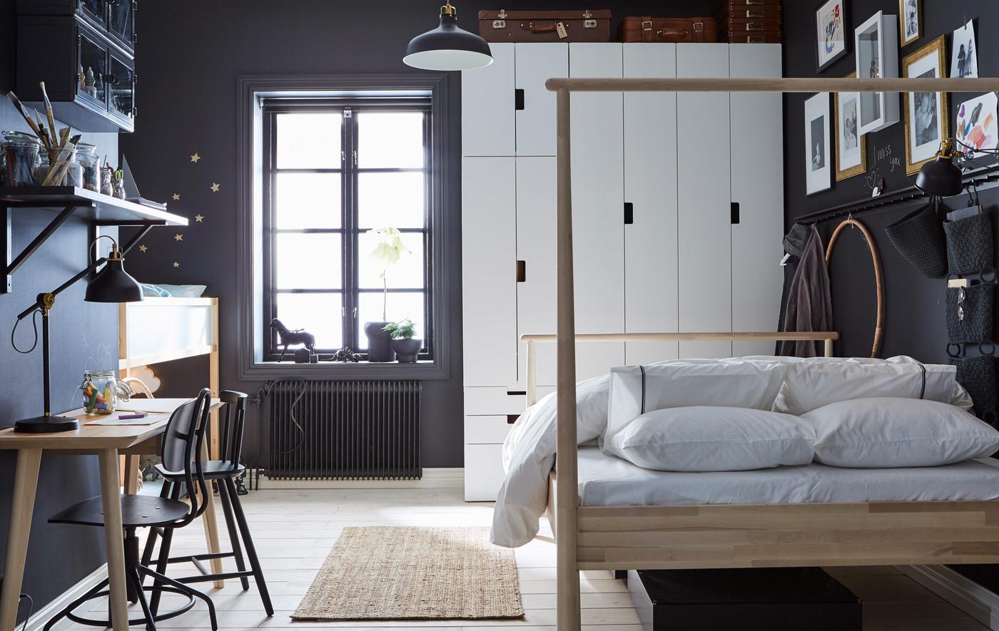 Una camera da letto nelle tonalità del grigio scuro e del bianco con un letto a soppalco per bambini, un letto matrimoniale, un armadio e una scrivania - IKEA.