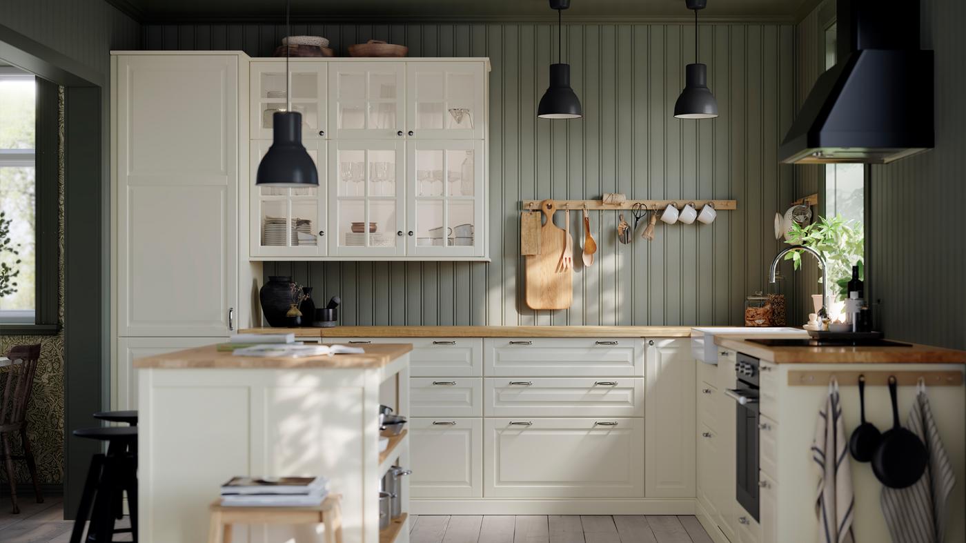 Una cucina con frontali di cassetti e ante BODBYN bianco sporco, lampade a sospensione HEKTAR e forno termoventilato MATTRADITION - IKEA.
