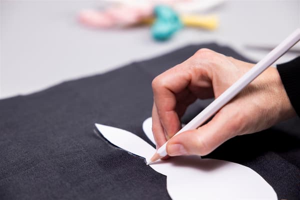 Una donna disegna un coniglio su un foglio nero 
