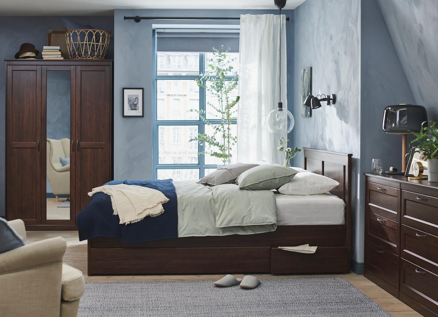 Una habitación con predominancia de azul, muebles de madera cafés oscuros.