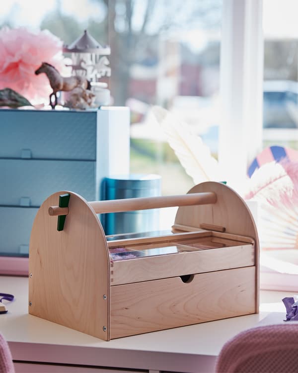Una habitación infantil con un acercamiento a un almacén de arte que está encima de un escritorio blanco.
