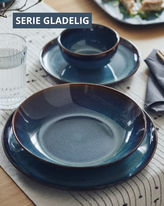 Una mesa con vajilla azul de la serie GLADELIG.