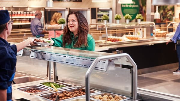 Una mujer a la que le sirven un plato caliente en el restaurante sueco de IKEA .