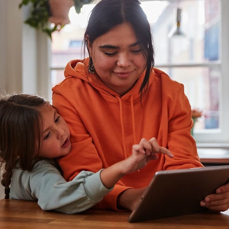 Una mujer y una niña mirando una tablet