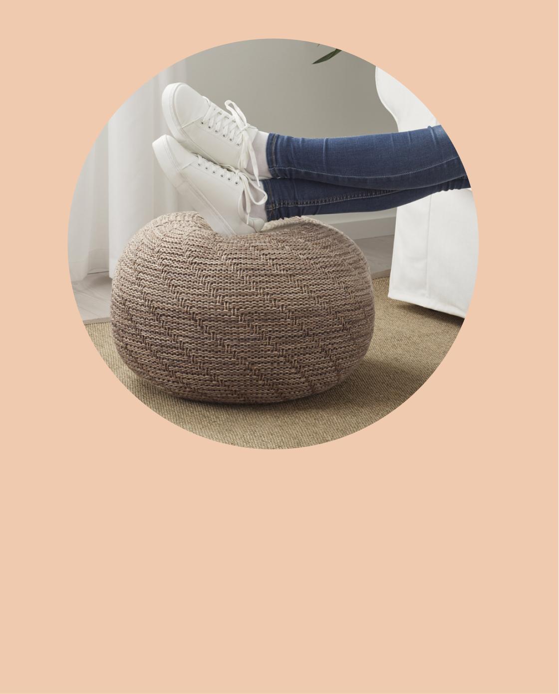 Una persona apoya sus pies en un puff IKEA para mantener las piernas estiradas y cómodas mientras descansa.