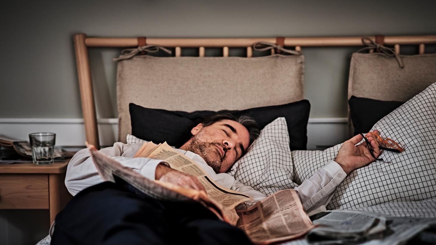 Una persona durmiendo en una cama BJÖRKSNÄS vestida con una funda nórdica ÅKERFIBBLA con 2 fundas de almohada.