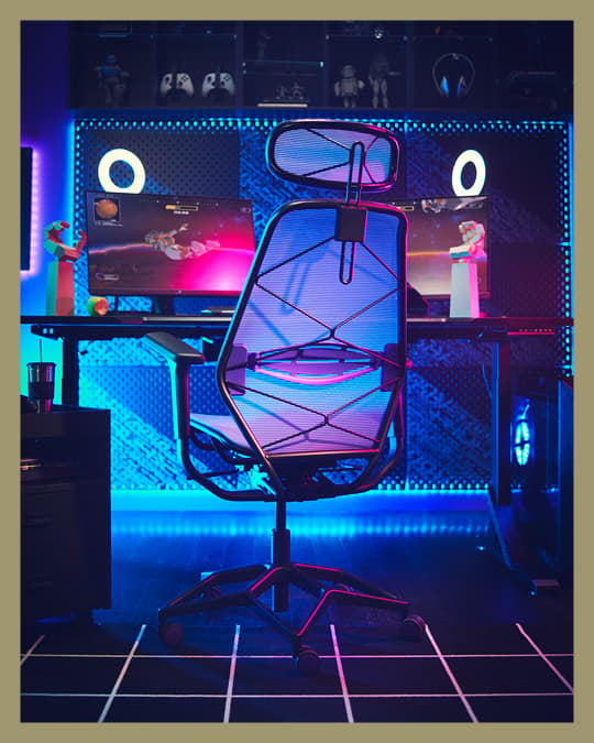 Una silla gamer frente a un pc con luces LED en tonos azules.