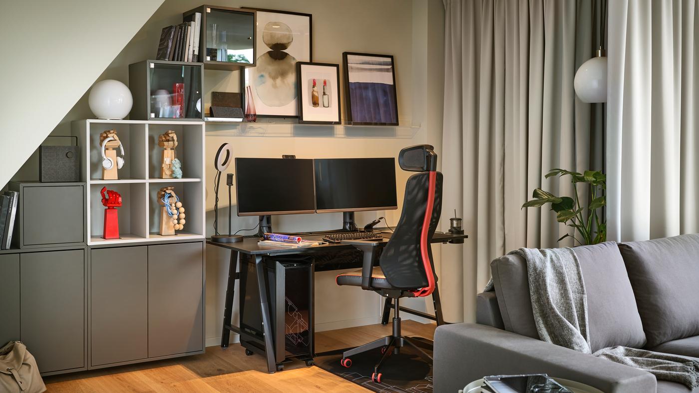 Una silla gamer MATCHSPEL y un escritorio gamer UTESPELARE en la esquina de una habitación gris con dos monitores y otros accesorios gamers.