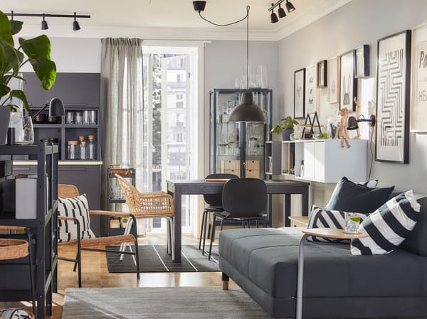 Una zona pranzo e un soggiorno in stile coordinato con mobili in rattan nei colori marrone, grigio e antracite - IKEA