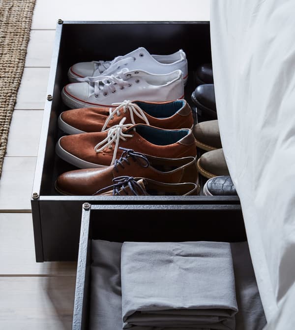 Under the bed storage boxes filled with shoes and bed linens.