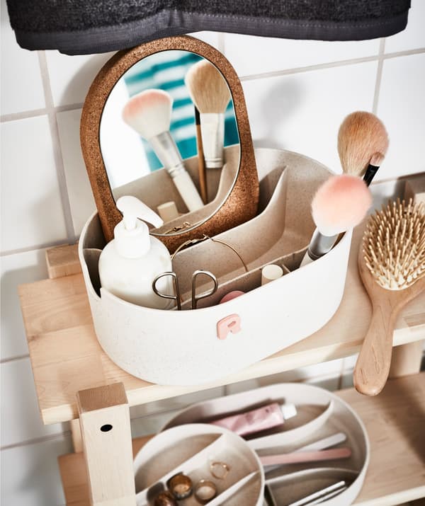 Une boîte remplie d’accessoires de beauté sur une étagère de salle de bain.