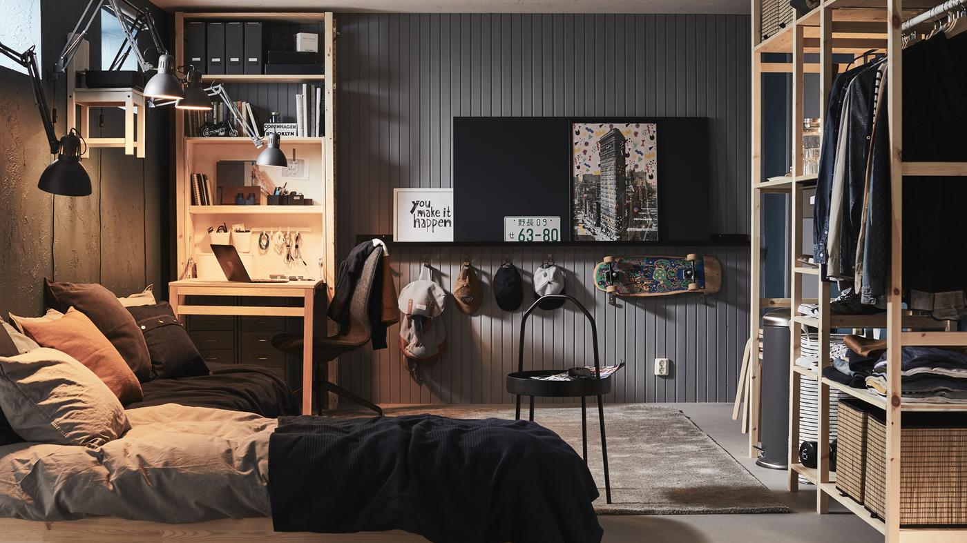 Une chambre à coucher avec un lit et du rangement incluant un grand agencement de tablettes IVAR et une unité de rangement IVAR avec table pliable.