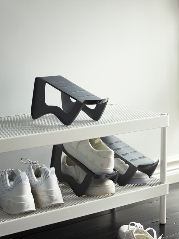 Une entrée avec une étagère à chaussures blanche à deux tablettes en treillis.