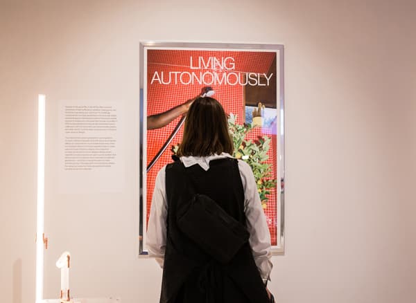 Une femme de dos regardant une affiche intitulée 