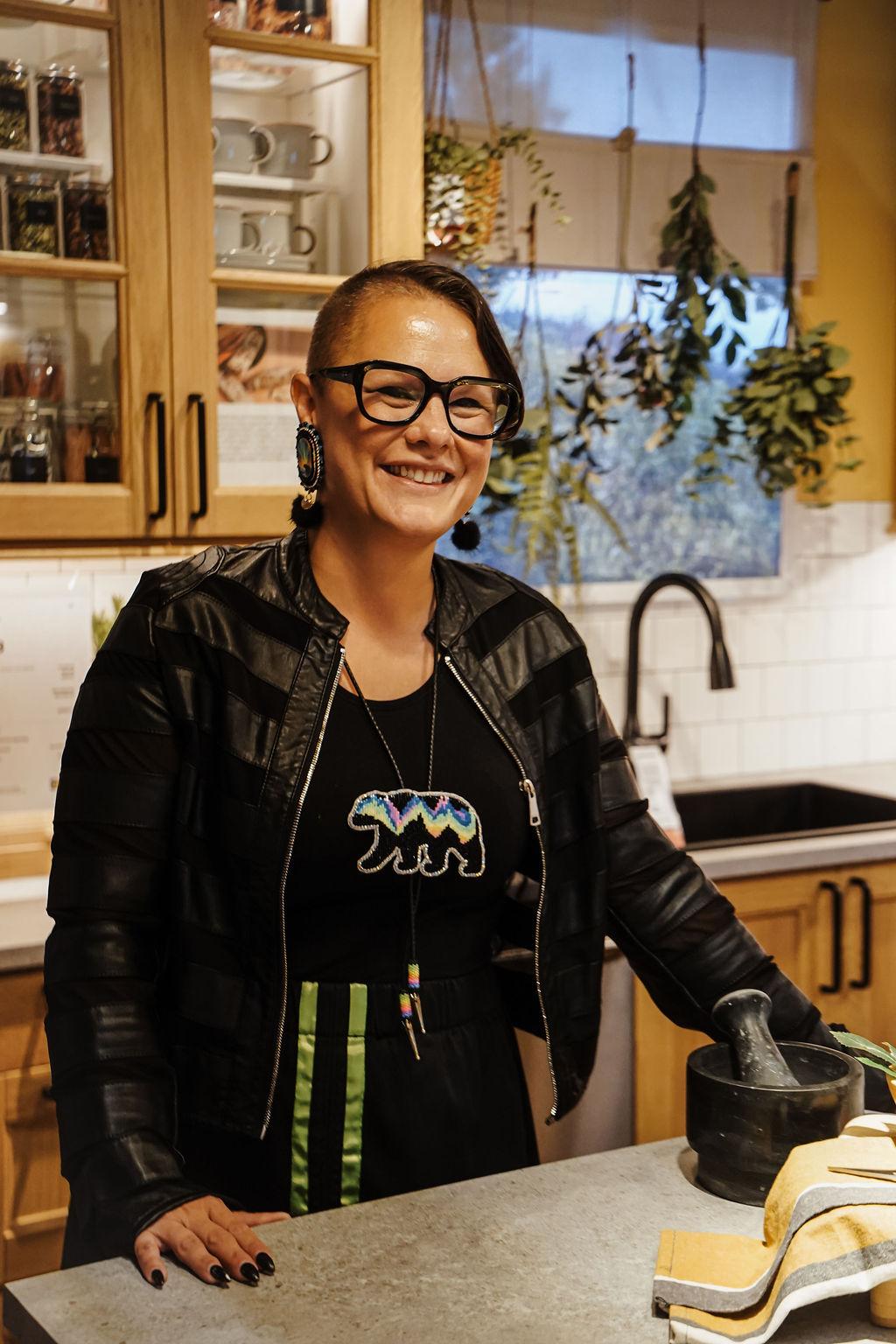 Une femme qui se tient près de l’îlot de cuisine sourit.