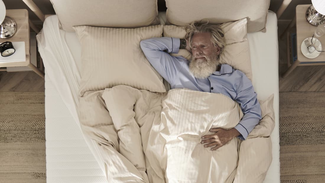 une personne dormant sur le dos dans un lit