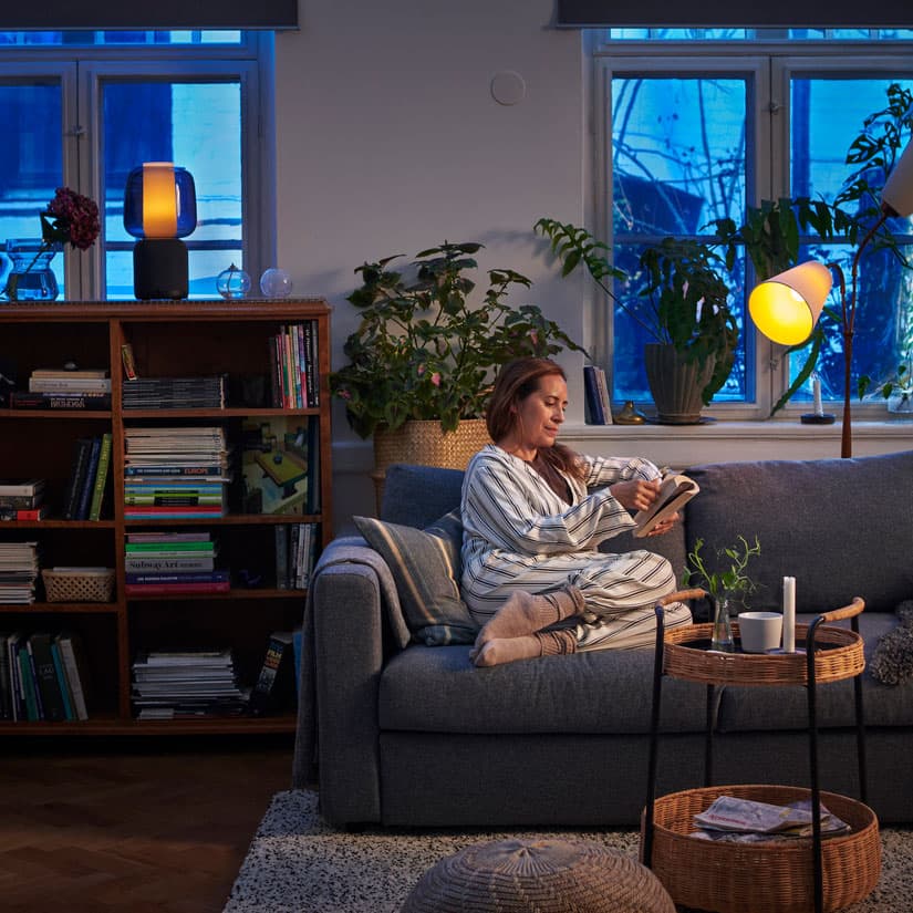 une personne sur son canapé utilisant l'application IKEA Home Smart
