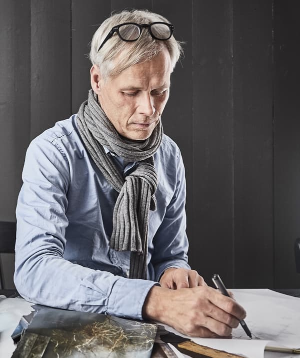 Une photo de Hans Blomquist dessinant sur une table.