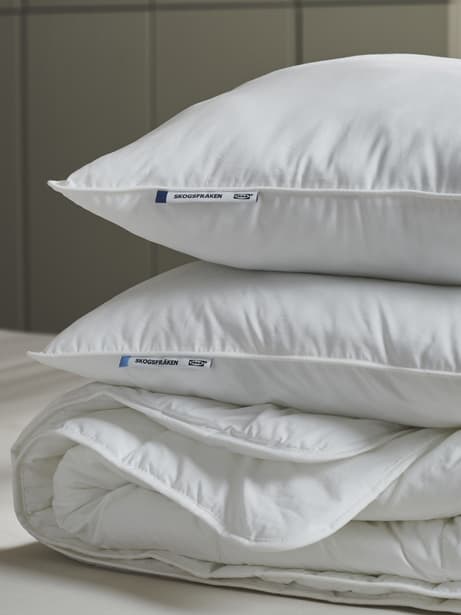 une pile de couettes blanches et d’oreillers
