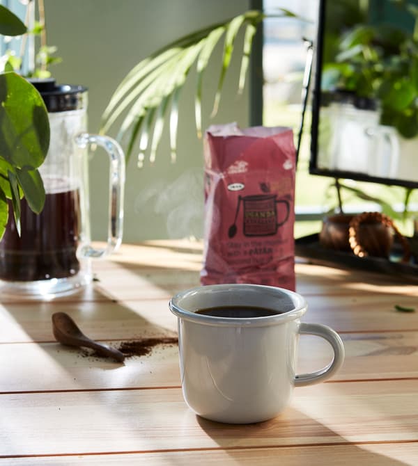 Une tasse blanche remplie de café à côté d’un emballage de café PÅTÅR.